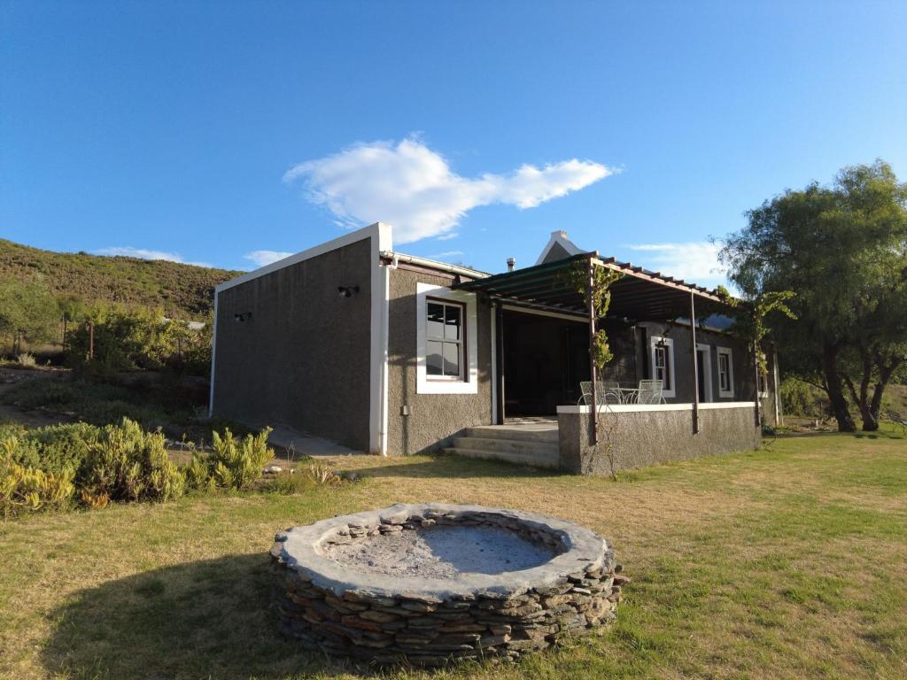 a house with a large tire in front of it at Matjiesvlei Cottages in Calitzdorp