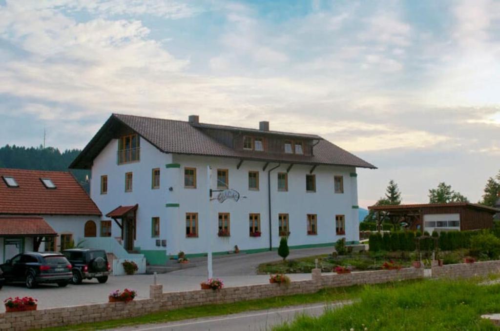 a large white building with cars parked in a parking lot at Ferienwohnung Frisch in Lam