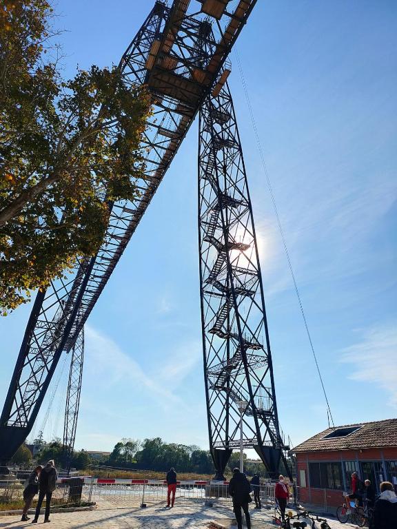 une grande tour métallique avec des gens debout en dessous dans l'établissement Maison au calme, à Rochefort