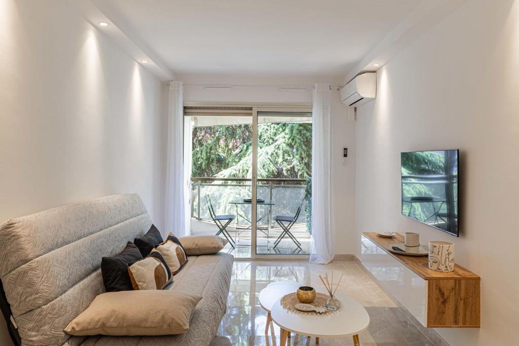 un salon avec un canapé et une table dans l'établissement LE CENTER avec joli balcon et parking pour un plaisant séjour, à Cannes