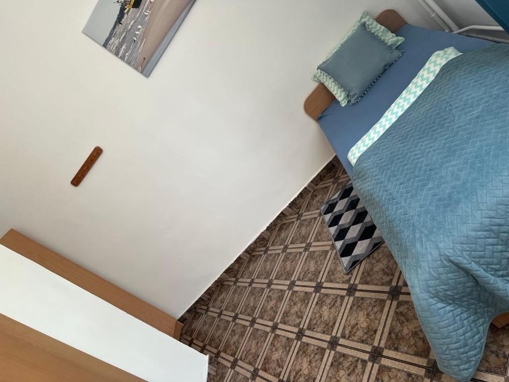 a bedroom with a bed with a blue blanket at Rybitwa in Dziwnów