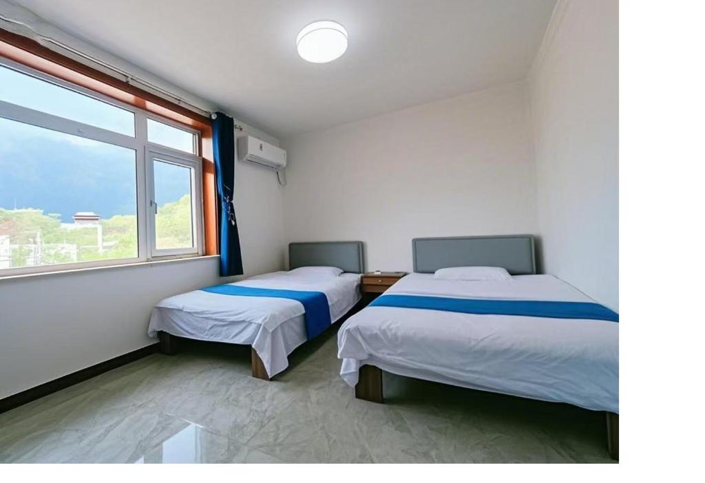 Postel nebo postele na pokoji v ubytování Gubeikou Great Wall Juxian Residents' Lodging