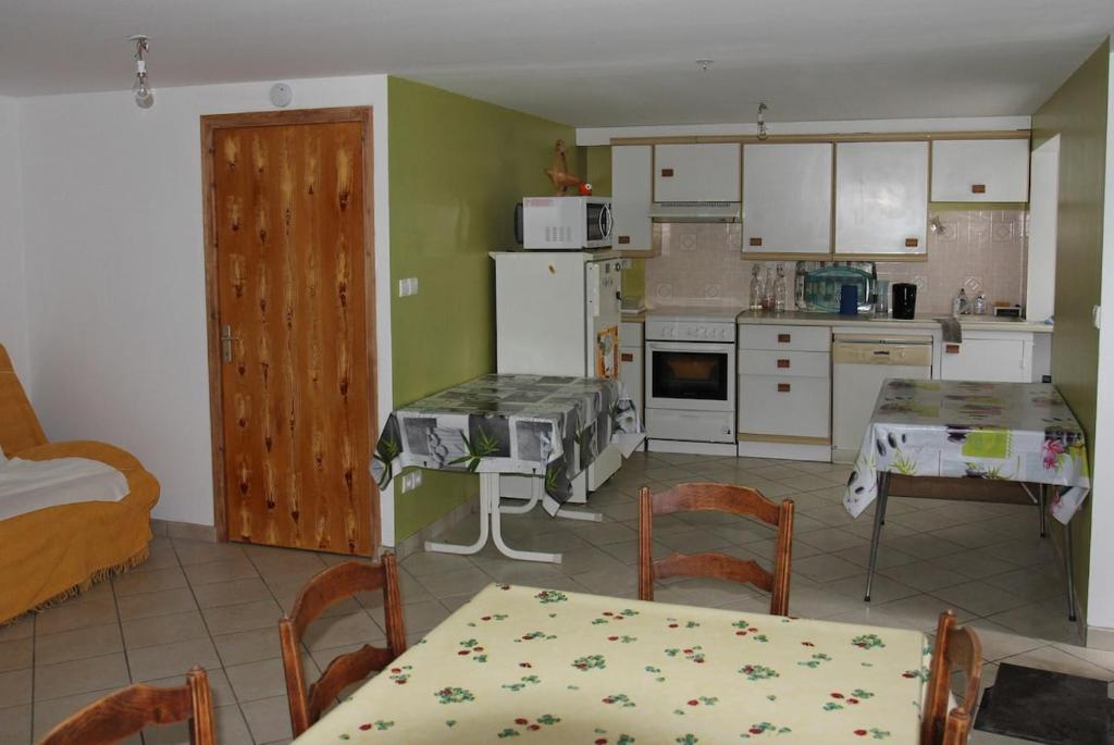 une cuisine avec une table et une salle à manger dans l'établissement Maison de campagne en Ardèche, à Arcens