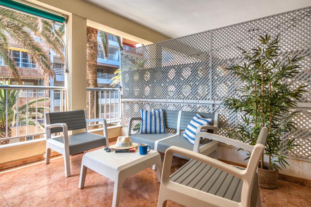 eine Terrasse mit Stühlen und einem Tisch auf einem Balkon in der Unterkunft La Terraza De Palmeres in Mareny Barraquetas