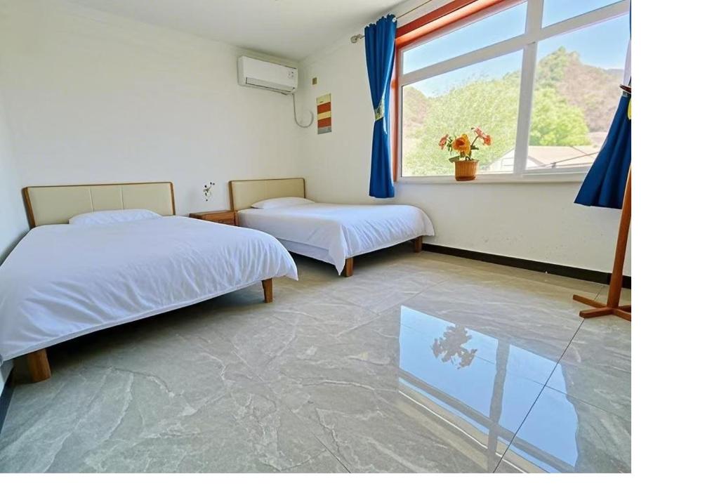 Postel nebo postele na pokoji v ubytování Gubeikou Great Wall Juxian Residents' Lodging