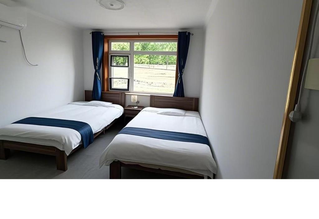 Postel nebo postele na pokoji v ubytování Gubeikou Great Wall Juxian Residents' Lodging