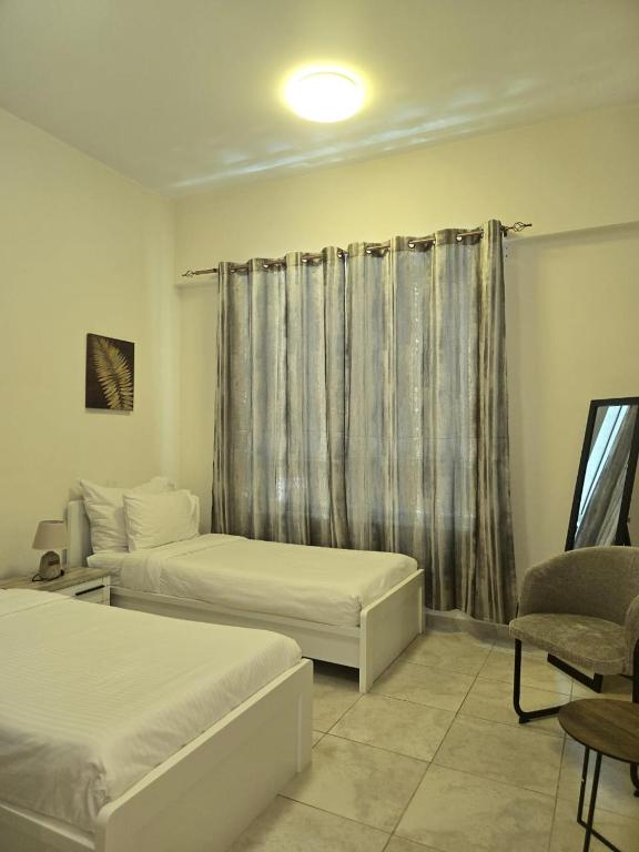 a hotel room with two beds and a window at Al Raya Hotel Apartments in Dubai