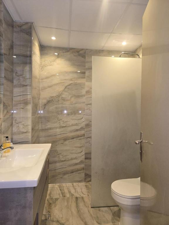 a bathroom with a toilet and a sink at Al Raya Hotel Apartments in Dubai