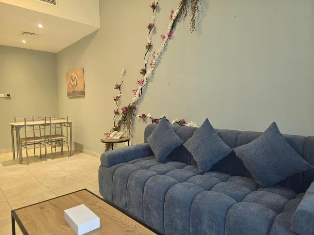 a living room with a blue couch and a table at Al Raya Hotel Apartments in Dubai