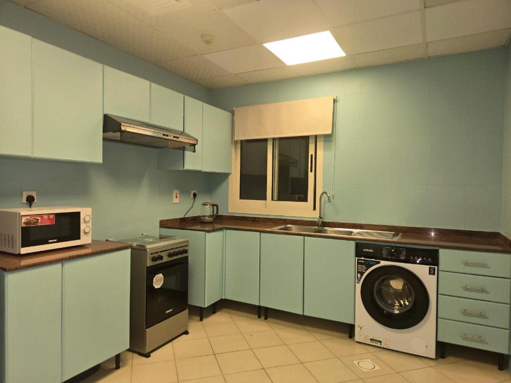 a kitchen with a washing machine and a washer at Al Raya Hotel Apartments in Dubai
