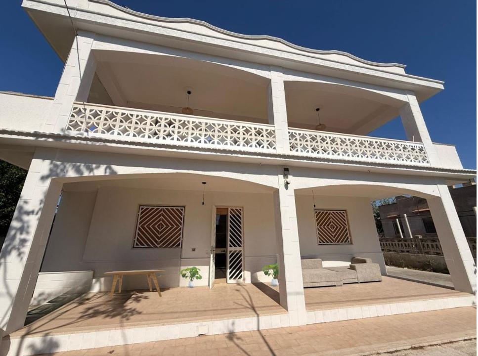 een wit huis met een balkon erbovenop bij Casa Mare Salento - a due passi dal mare in Marina di Lizzano