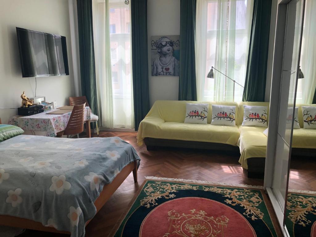 uma sala de estar com um sofá amarelo num quarto em Apartment Gute Laune-Good mood em Viena