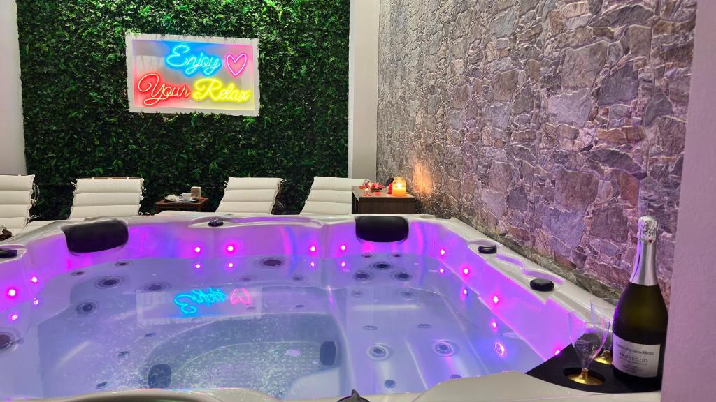 a hot tub in a room with a bottle of wine at beb Sicily in Love in Taormina
