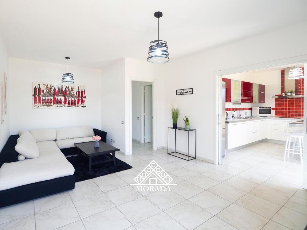 un soggiorno bianco con un divano e un tavolo di Casa Maura - MORADA a Iglesias