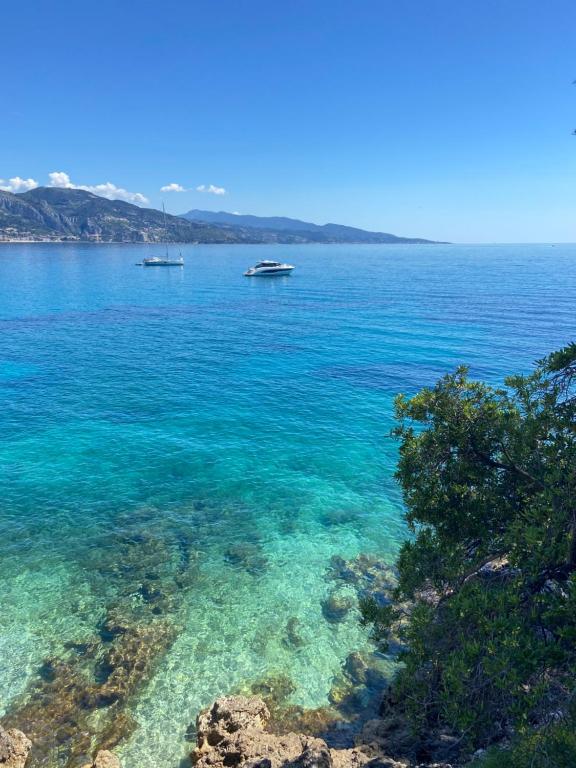 une vue sur l'océan avec des bateaux dans l'eau dans l'établissement Studio front mer, Résidence piscine (privée), à Roquebrune-Cap-Martin