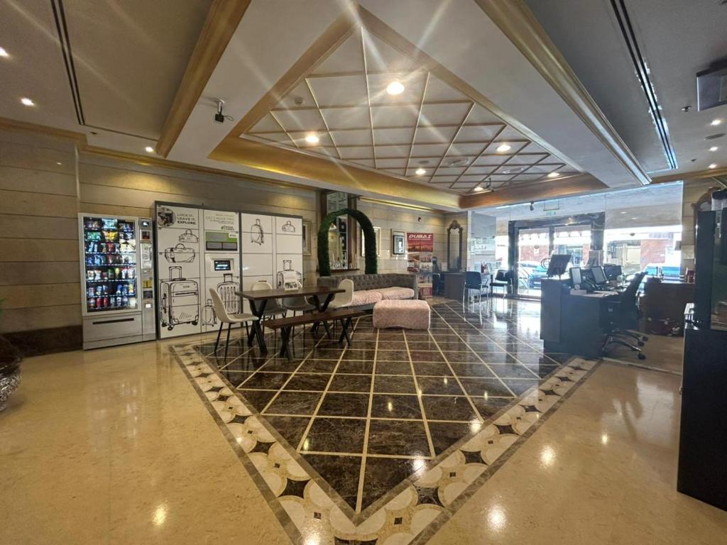 a lobby with a tiled floor with a table and chairs at Al Raya Hotel Apartments in Dubai