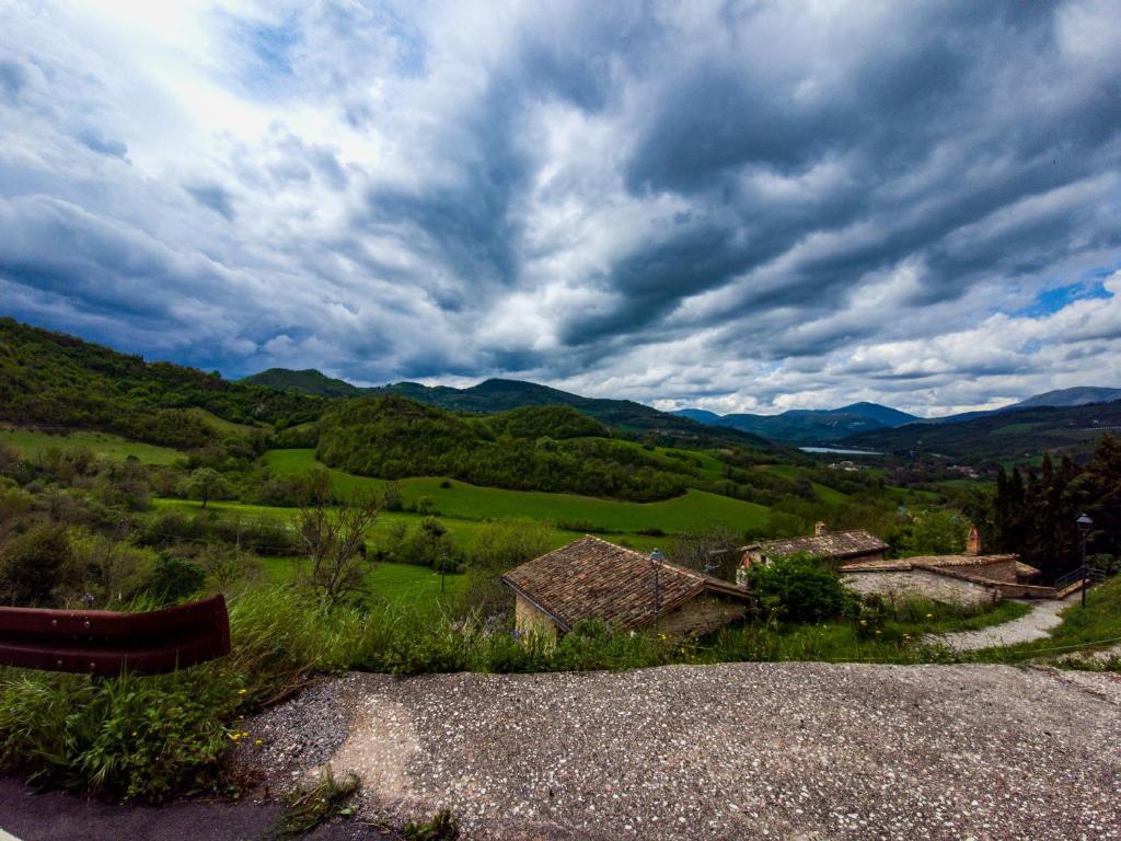 a view of a green valley with a cloudy sky at Monti sibillini house in Pievebovigliana