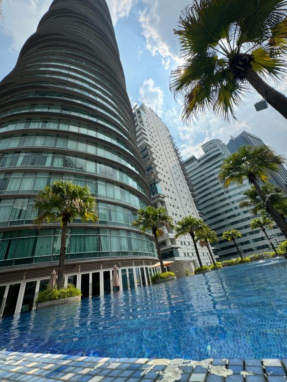 a tall building with a swimming pool in front of it at Vortex Suites Klcc 2bedroom & 3bedroom apartment in Kuala Lumpur