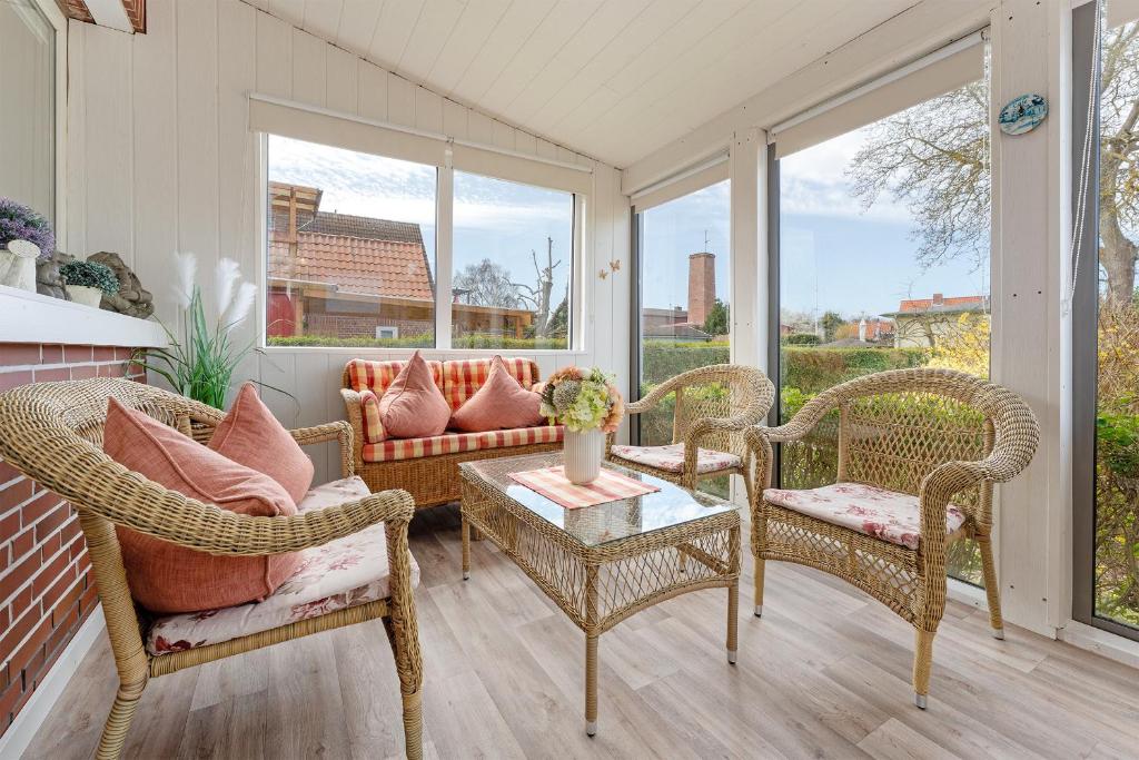 un porche avec des chaises en osier et un canapé dans l'établissement Kajüte Nr 1, à Neue Tiefe Fehmarn