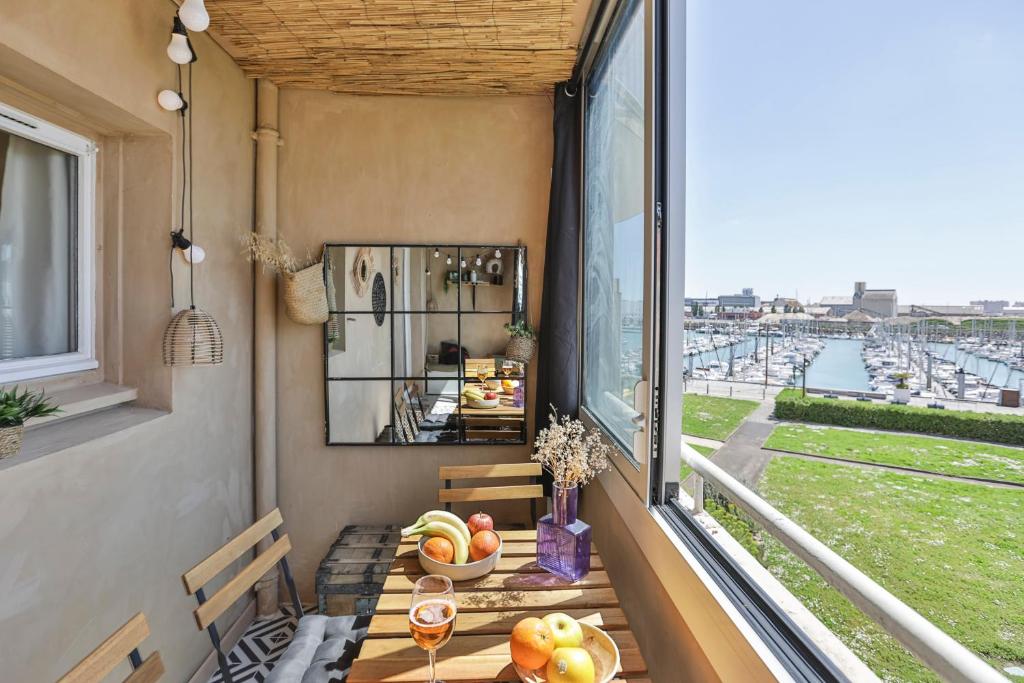 d'un balcon avec une table et une fenêtre offrant une vue. dans l'établissement La petite escapade - Cosy - Vue Port, à Les Sables-dʼOlonne