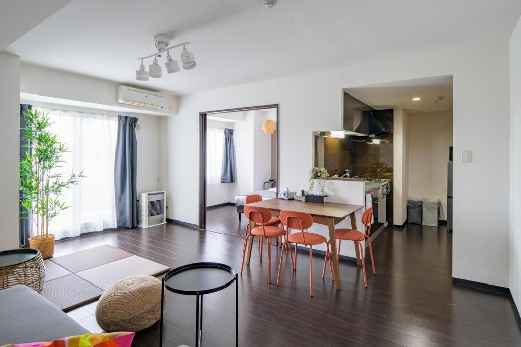 a living room and kitchen with a table and chairs at Sun North in Sapporo