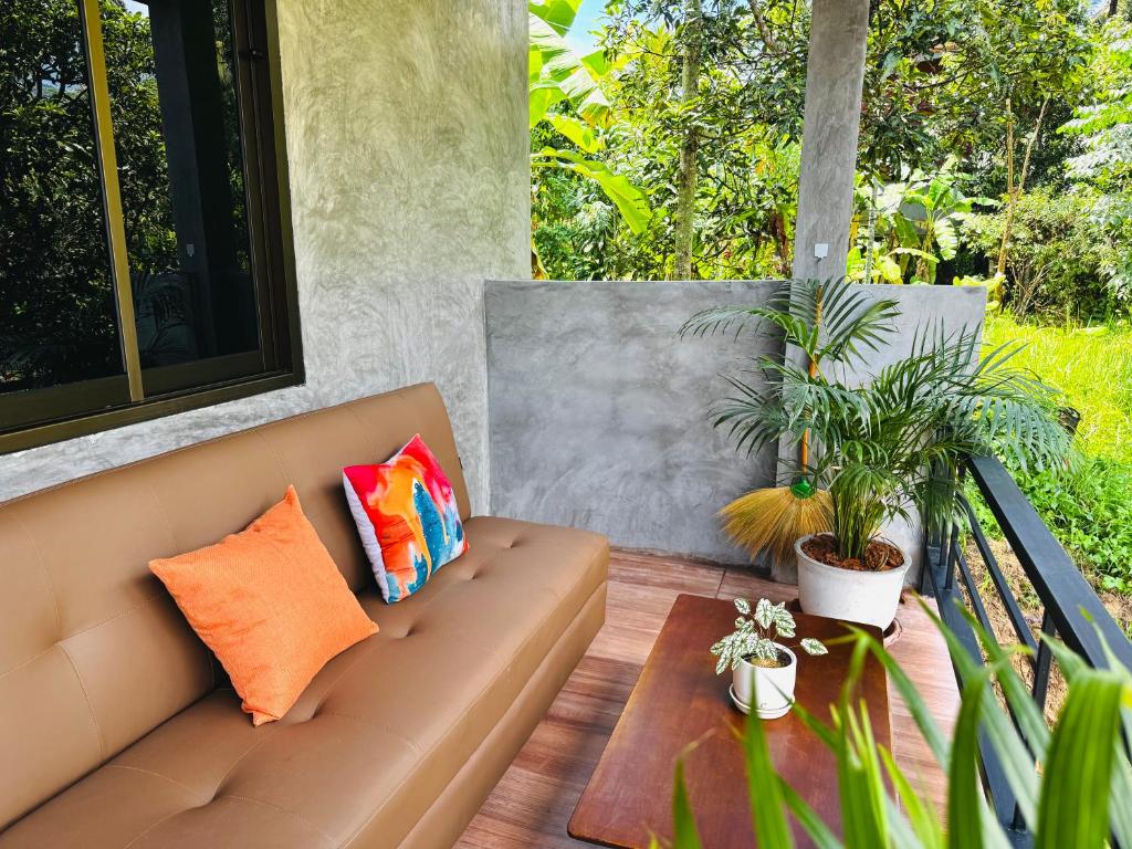 a couch on a patio with a table and plants at Bantai Hideaway - House 1 in Baan Tai