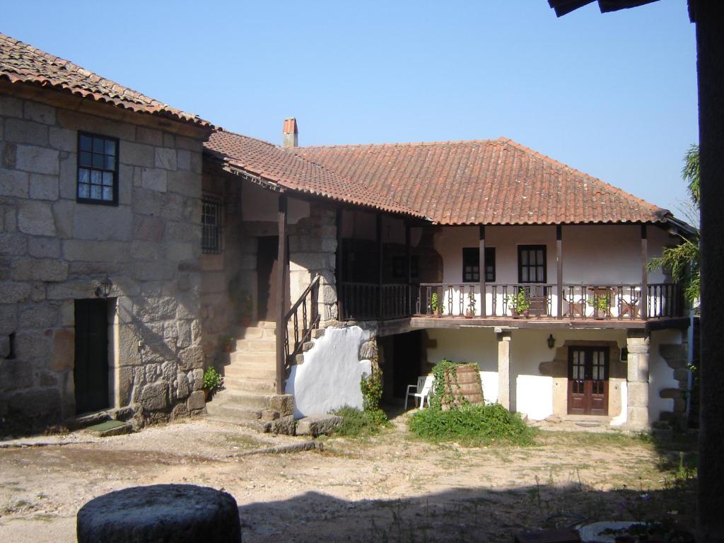 uma antiga casa de pedra com um alpendre e uma varanda em Quinta Santa Isabel em Chaves