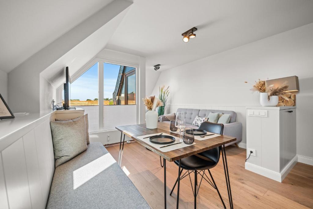 a living room with a table and a couch at Traumloft Wenningstedt in Wenningstedt