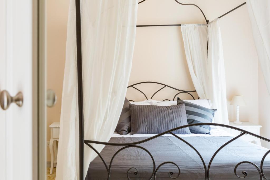 a bedroom with a black canopy bed with pillows at G-House Pettinari in Rome