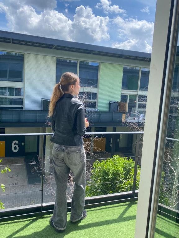 Camarma de EsteruelasにあるVistas al campoの窓を見下ろすバルコニーに立つ女性