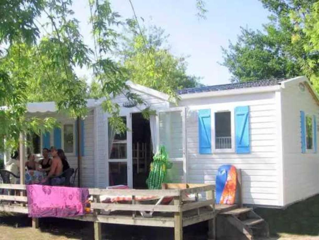 a group of people sitting outside of a tiny house at Camping 5 étoiles - Parc aquatique - eebdba in Mézos