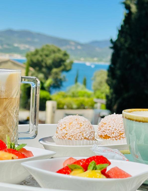 a table with plates of food and cups of coffee at Les Capucines Saint Tropez in Saint-Tropez