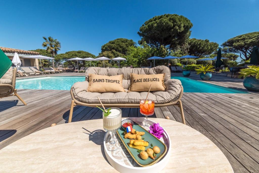 a tray of food on a table next to a pool at Les Capucines Saint Tropez in Saint-Tropez