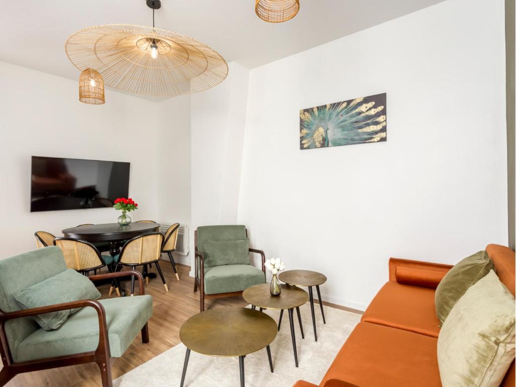 een woonkamer met een bank, een tafel en stoelen bij Merveil - Family Suite - Opera - Caumartin II in Parijs