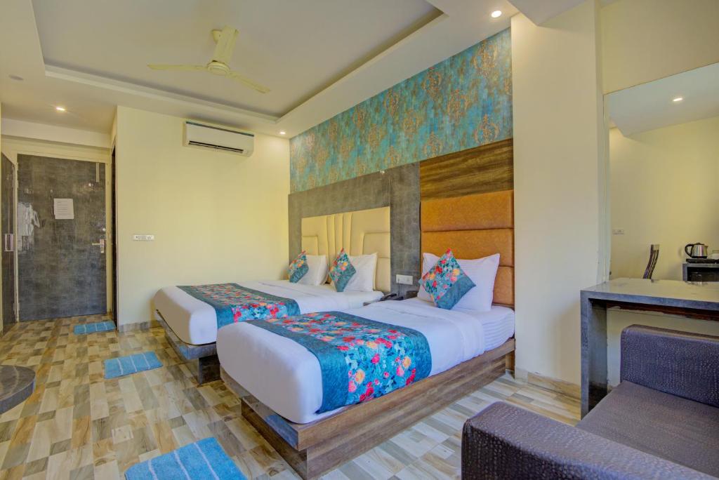 una camera d'albergo con due letti e un camino di Smart Lax Hotel By SMART GROUP a Nuova Delhi