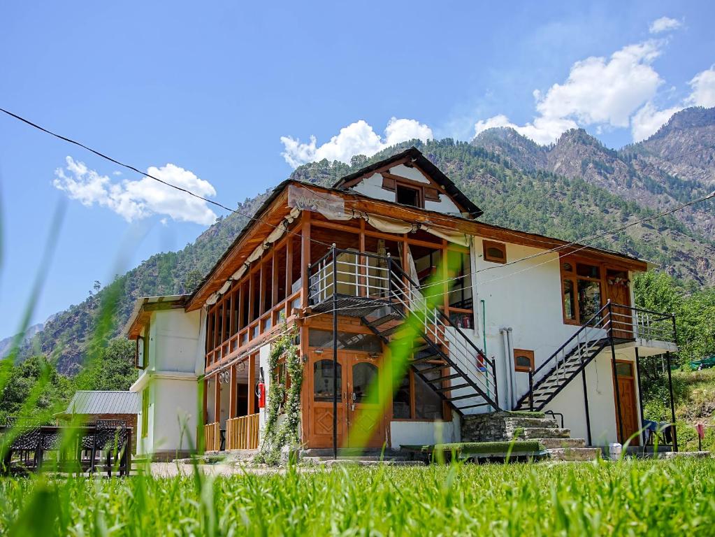 ein Haus mit einer Treppe vor einem Berg in der Unterkunft Moksha Woodhouse in Kasol
