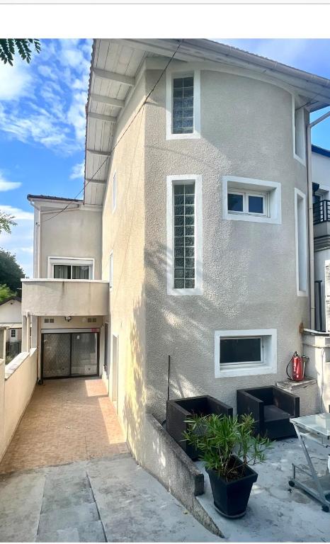 une grande maison blanche avec une allée en face de celle-ci dans l'établissement Maison idéale pour grand groupe, à Villiers-le-Bel