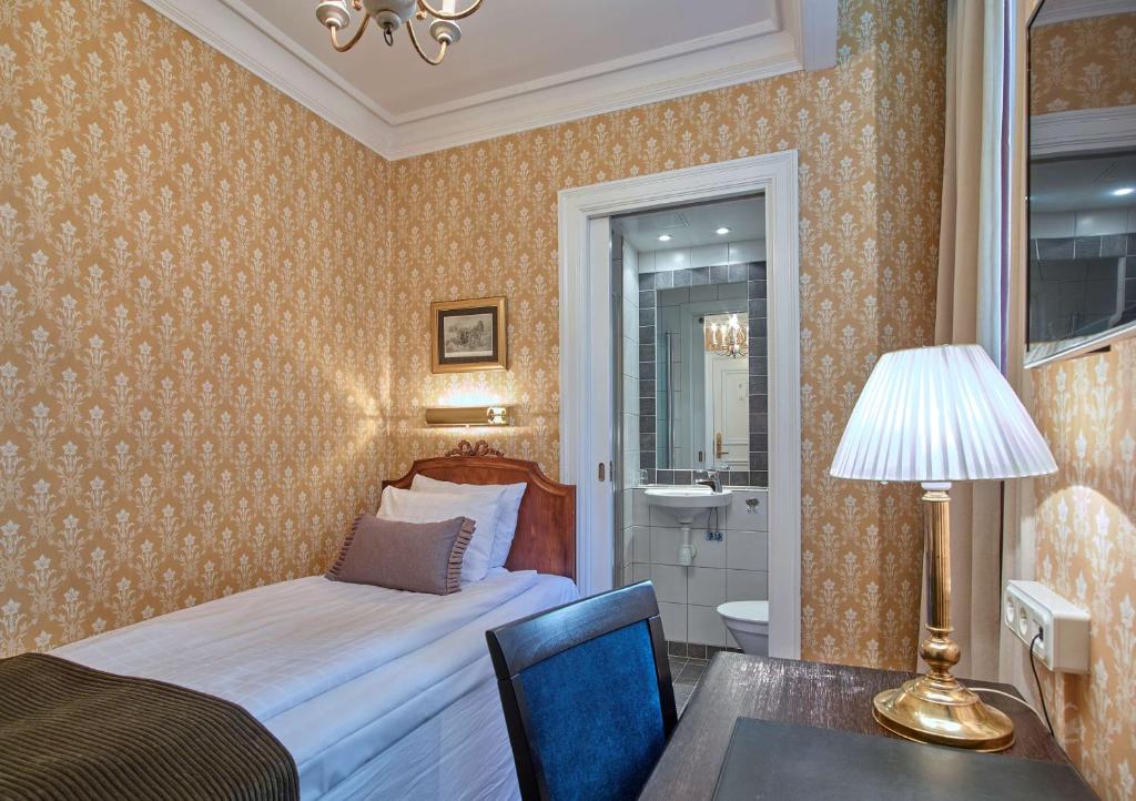 a bedroom with a bed and a table and a lamp at Scandic Gamla Stan in Stockholm