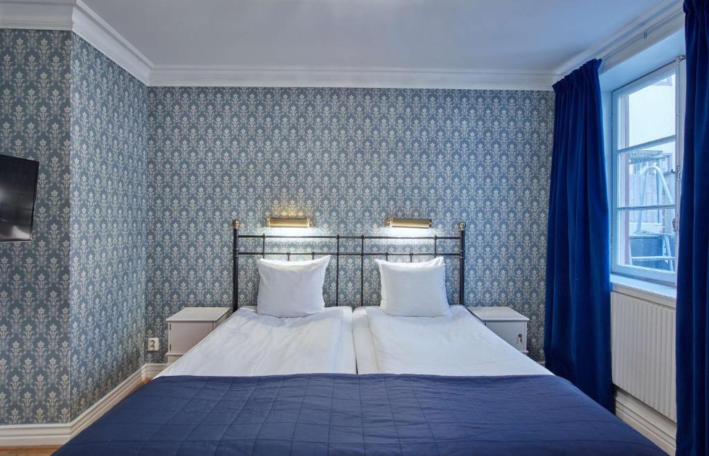 a bedroom with a bed with blue wallpaper at Scandic Gamla Stan in Stockholm