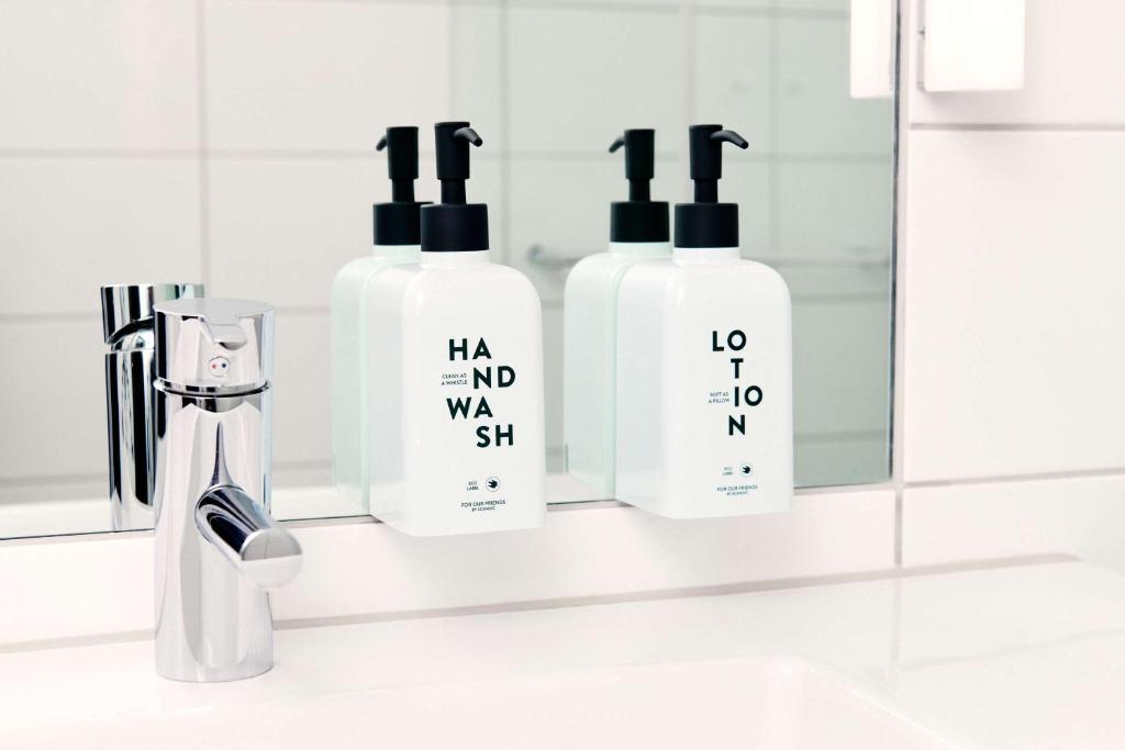 a bathroom with two bottles of shampoo and a mirror at Scandic Gamla Stan in Stockholm