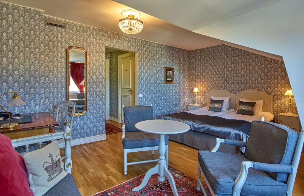 a hotel room with a bed and a table and chairs at Scandic Gamla Stan in Stockholm