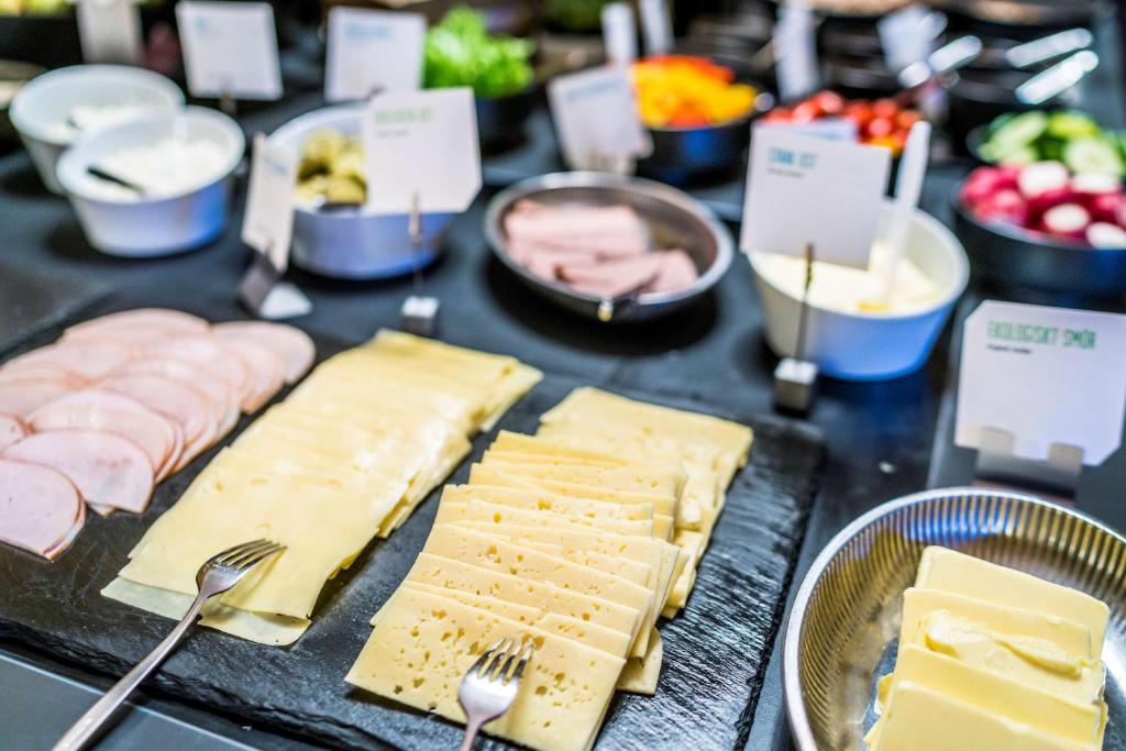 a table with cheese and meats and other foods at Scandic Gamla Stan in Stockholm