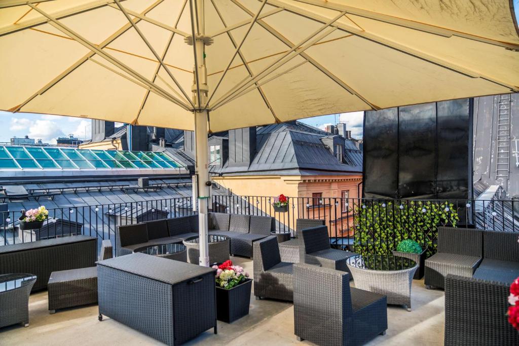 a rooftop patio with chairs and an umbrella at Scandic Gamla Stan in Stockholm