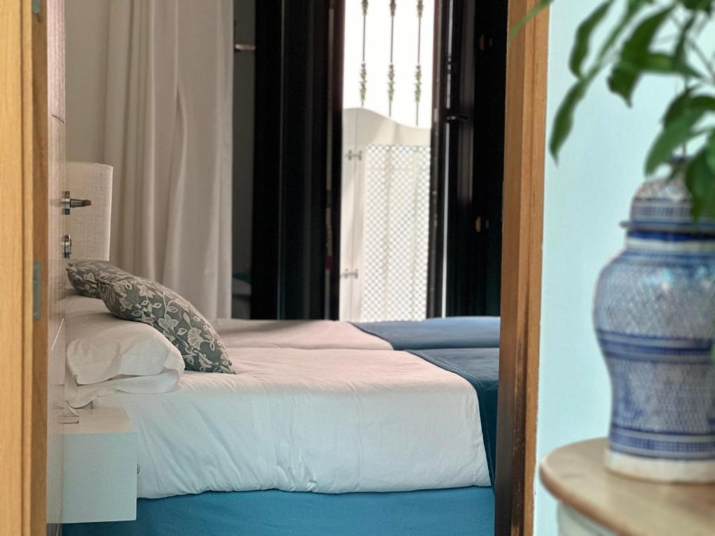 a bedroom with a bed and a mirror at Hostal Casa Alborada in Conil de la Frontera