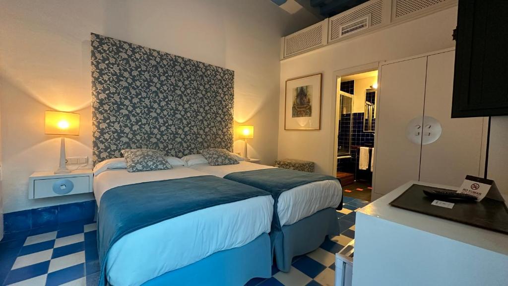 a bedroom with a large bed in a room at Hostal Casa Alborada in Conil de la Frontera