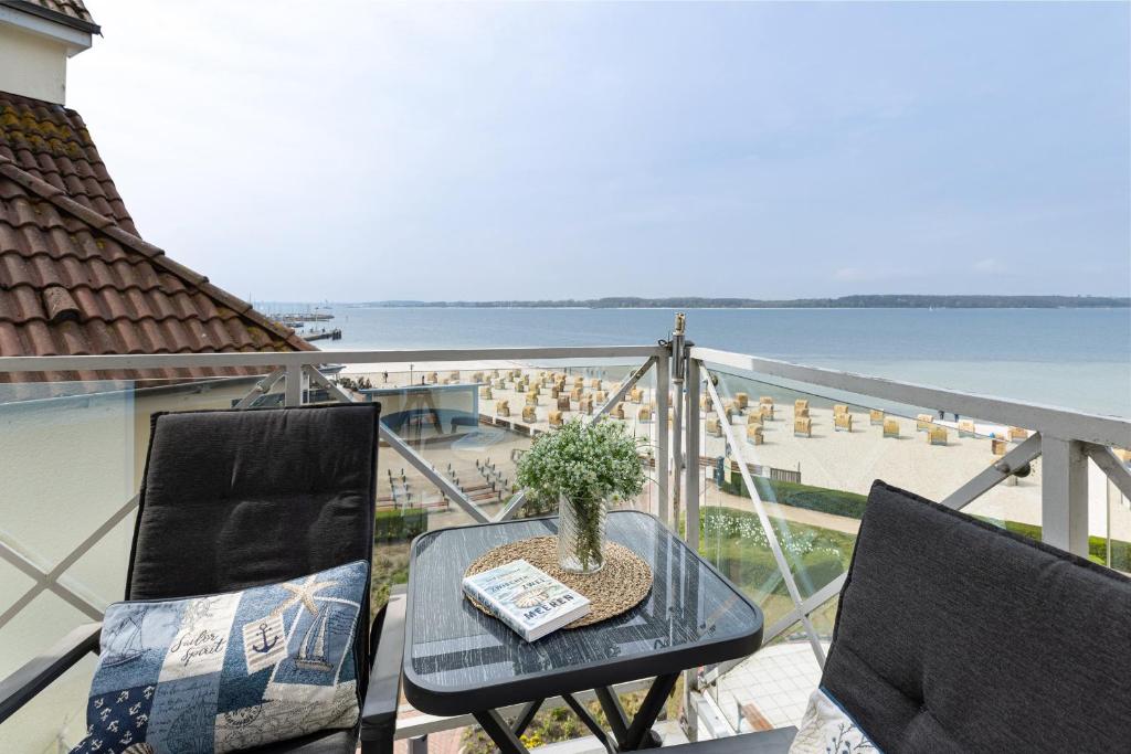 a table and chairs on a balcony with a view of the ocean at Strandhotel Laboe Nr 35 in Laboe