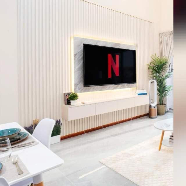 a living room with a flat screen tv on a wall at Emirat Premium DxB in Sabkhah