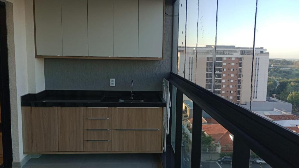 a kitchen with a sink and a balcony at Studio 803 in Marília