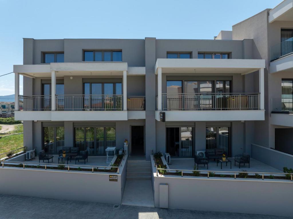 a building with balconies and tables and chairs at Avanto Apartments Lefkas Awaits in Lefkada