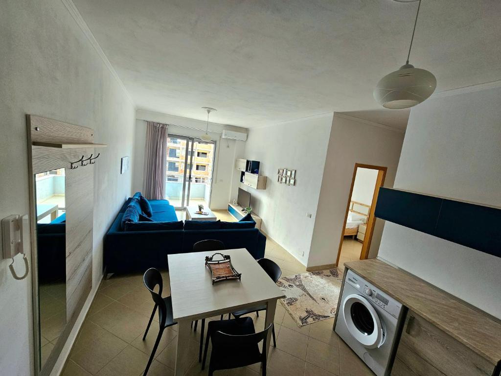 a living room with a blue couch and a table at Vlora Beach Apartment Orikum in Orikum
